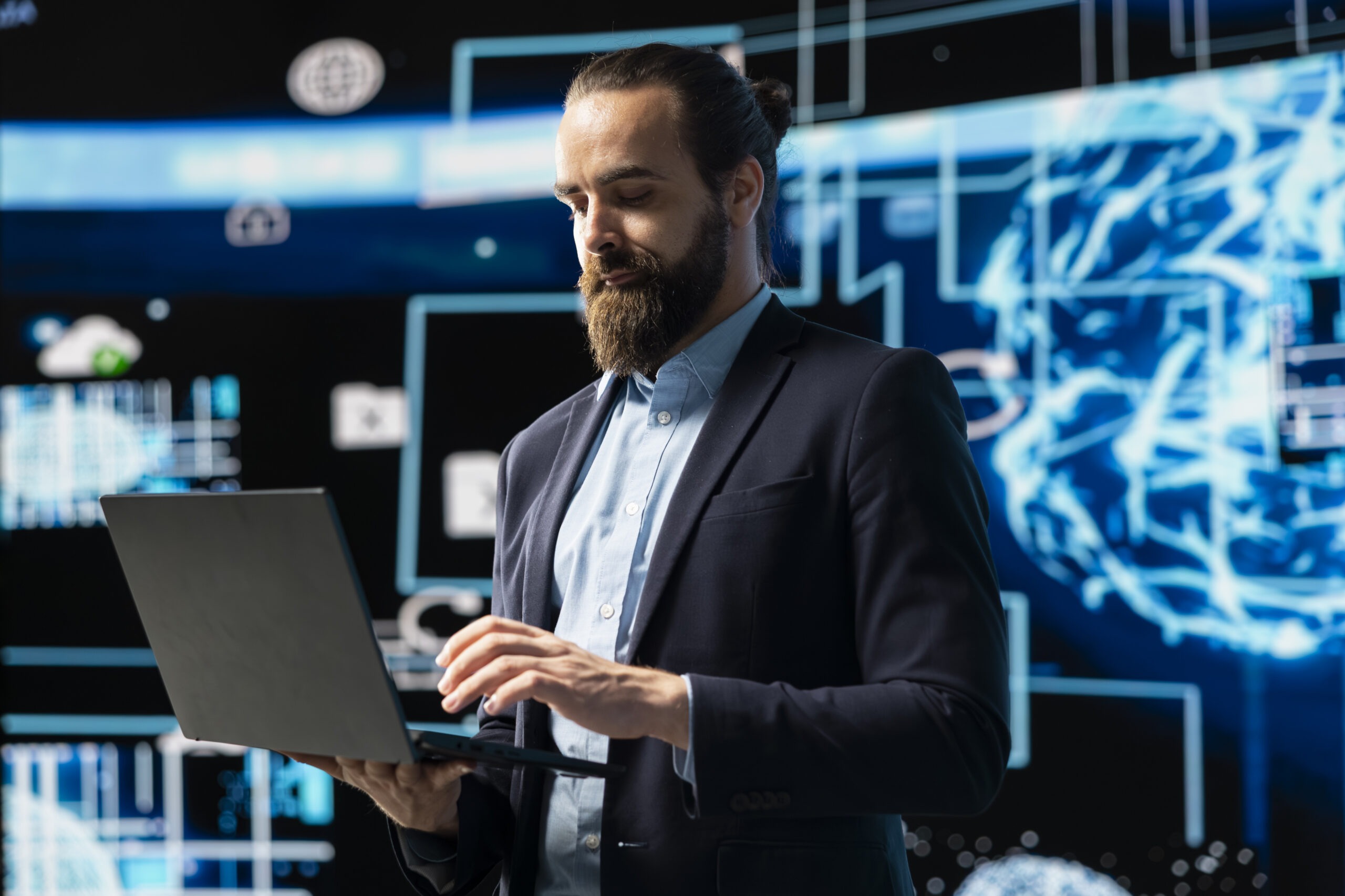 Senior Cybersecurity Consultant Reviewing Data on a Laptop in a Secure Operations Room